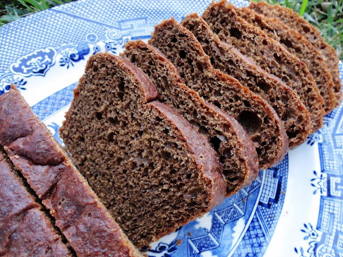 sliced loaf of brown bread sitting on top of a blue and white plate