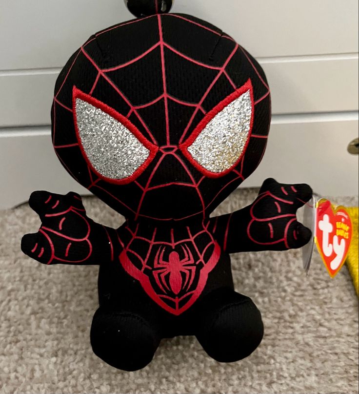 a spiderman stuffed animal sitting on the floor