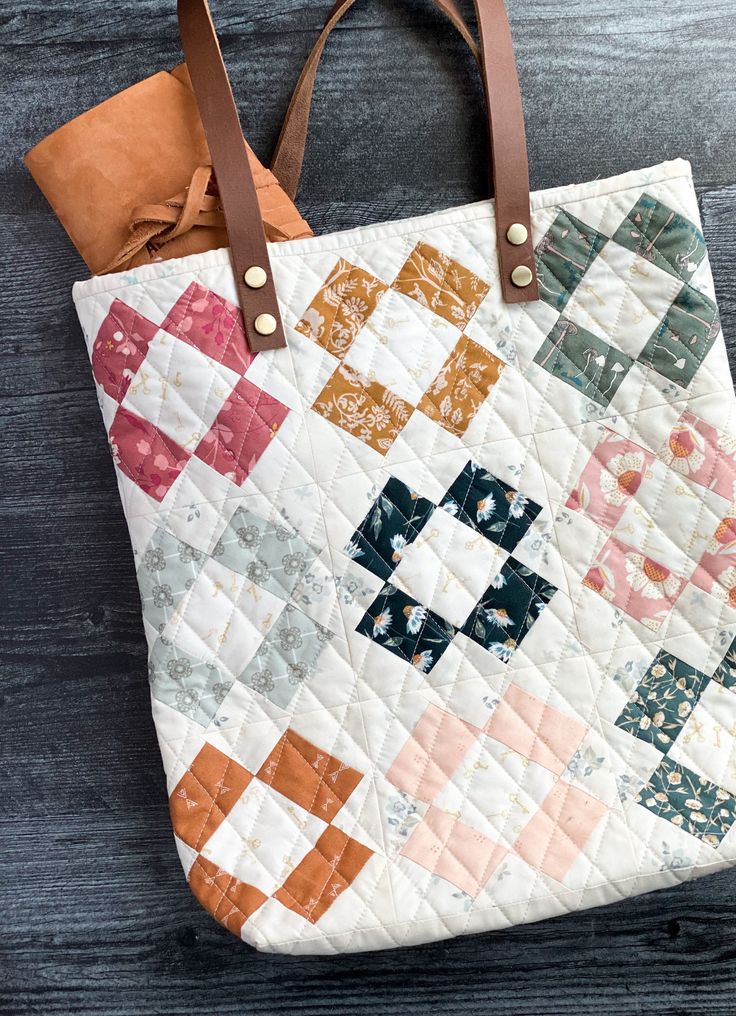 a quilted bag sitting on top of a wooden table