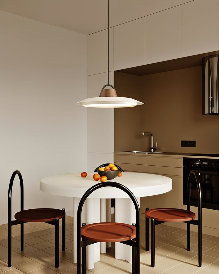 a white table and chairs in a small room with an oven on the far wall