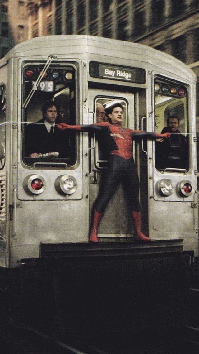 a spiderman is standing on the door of a subway car