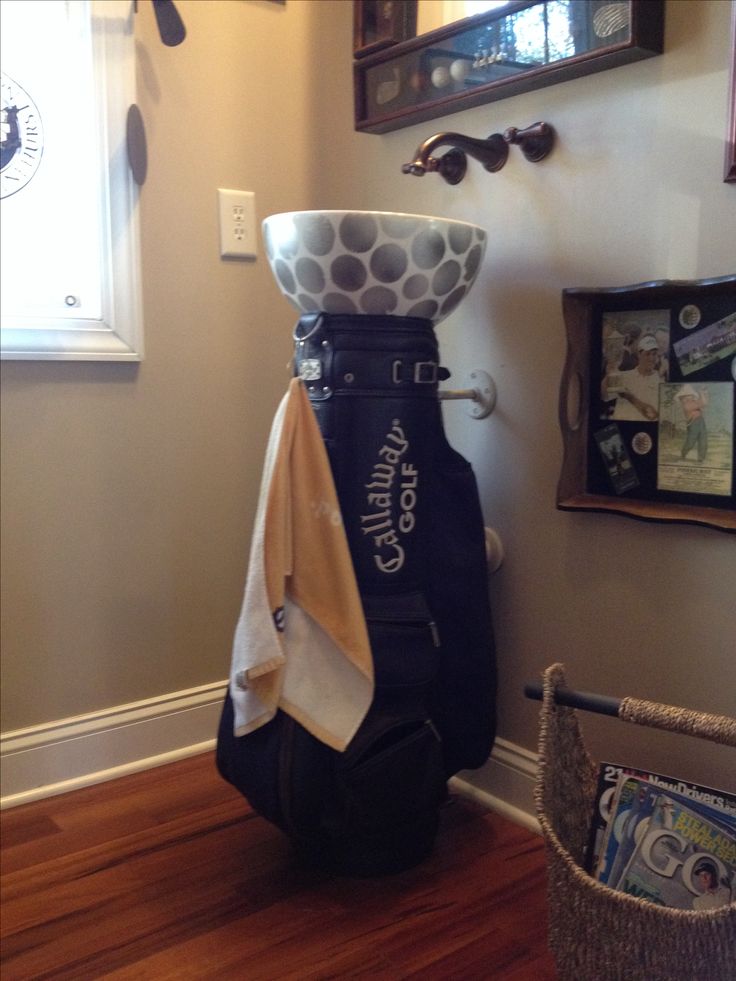 a golf bag sitting on top of a hard wood floor next to a wall mounted clock