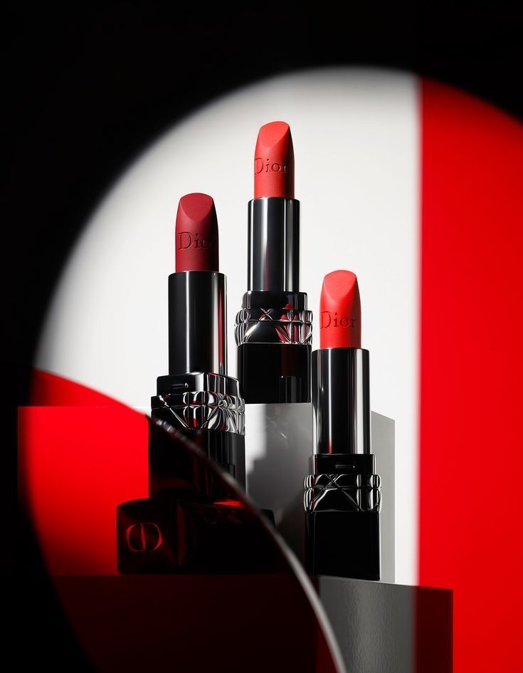 a group of lipsticks sitting next to each other on a red and white table