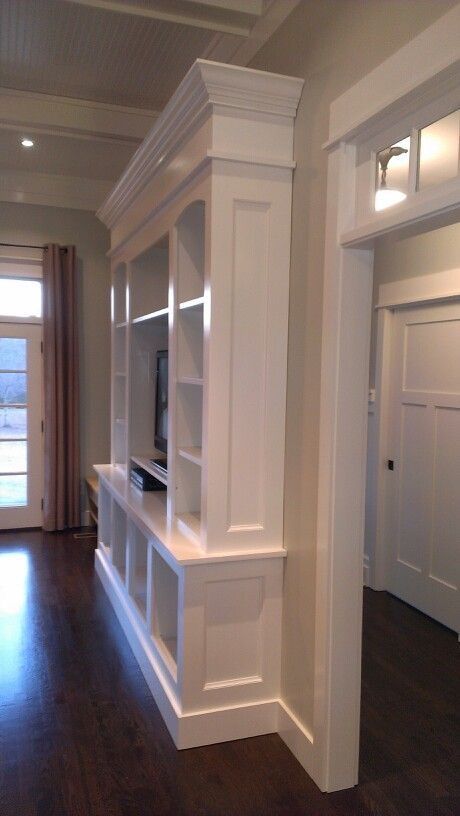 an empty living room with built in bookshelves