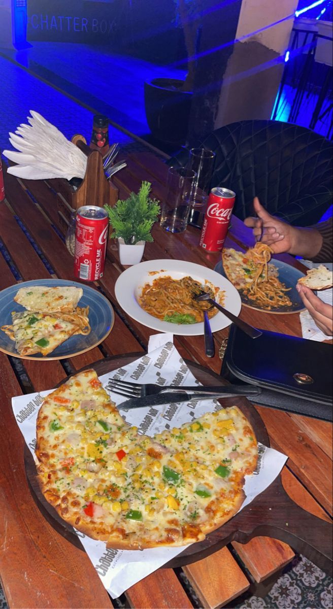 a table topped with pizza and other food