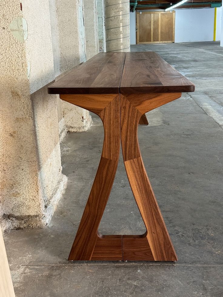 a wooden table sitting on top of a cement floor