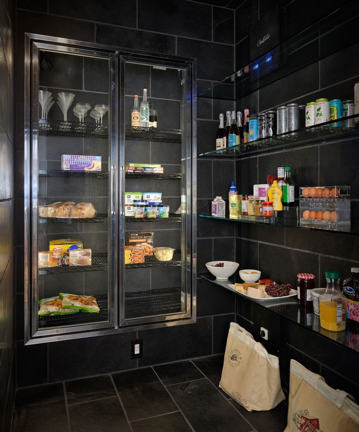 a refrigerator with food inside of it next to shelves filled with drinks and condiments