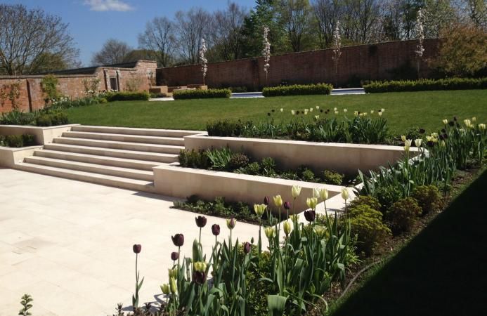 a garden with steps and flowers in the middle