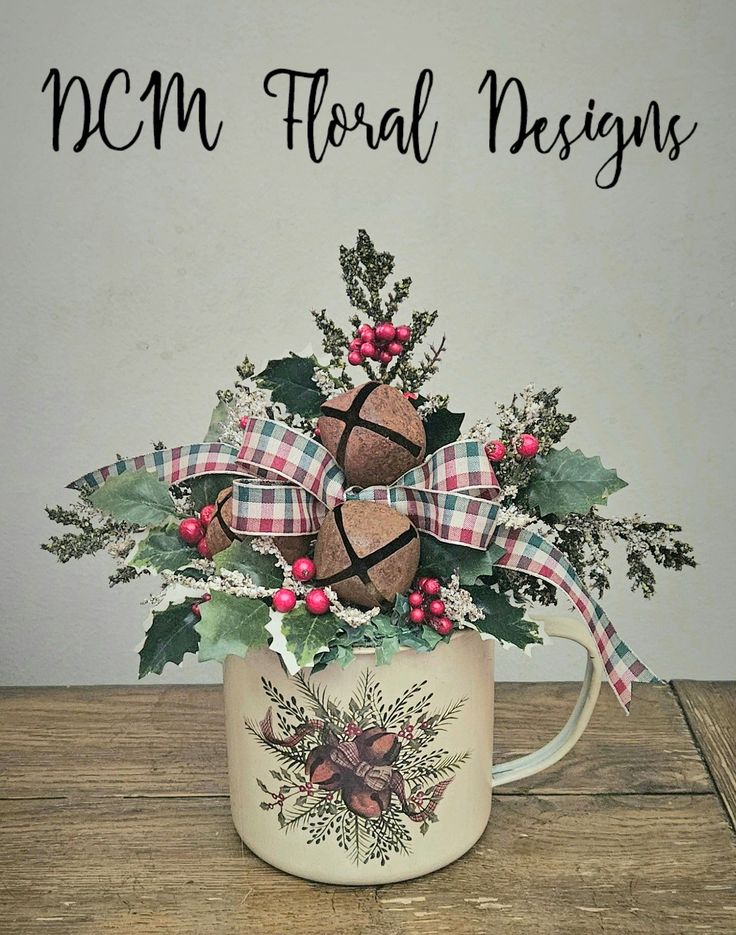 a coffee mug filled with holly and pine cones