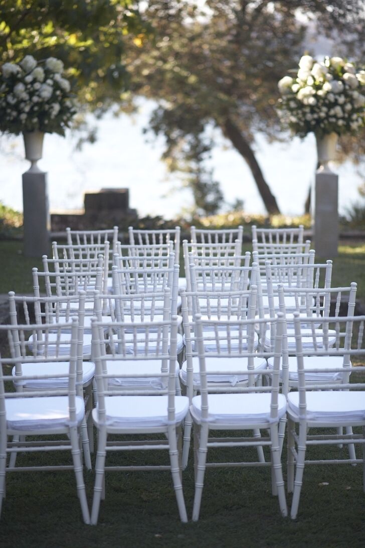 rows of white chairs sitting on top of a lush green field