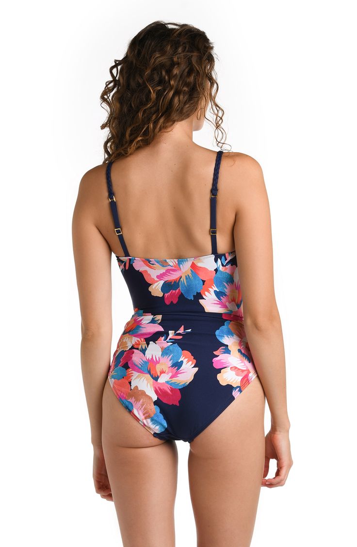 Blossom into beachside beauty with this swimsuit adorned in an enchanting indigo and pink multicolored floral print, capturing the allure of a vibrant garden by the sea. With a simple, classic silhouette, this one-piece knows exactly how to flatter the figure with allover shirring. A scooped neckline reveals just the right amount of skin to keep the look sexy yet simple. Guaranteed to be your go-to this season, it holds everything up and in so you can confidently go about your day, whether sitti Blue Floral Print Summer Tankini, Blue Floral Print Swimwear For Beach Party, Blue Tropical Swimwear With Floral Print, Blue Floral Print Tankini For Pool, Blue Floral Print Tankini For Poolside, Beachy One-piece Floral Print Swimwear, Summer Floral Print Tankini For Poolside, Beachy Fitted Floral Print Tankini, Blue Floral Print Swimwear For Pool