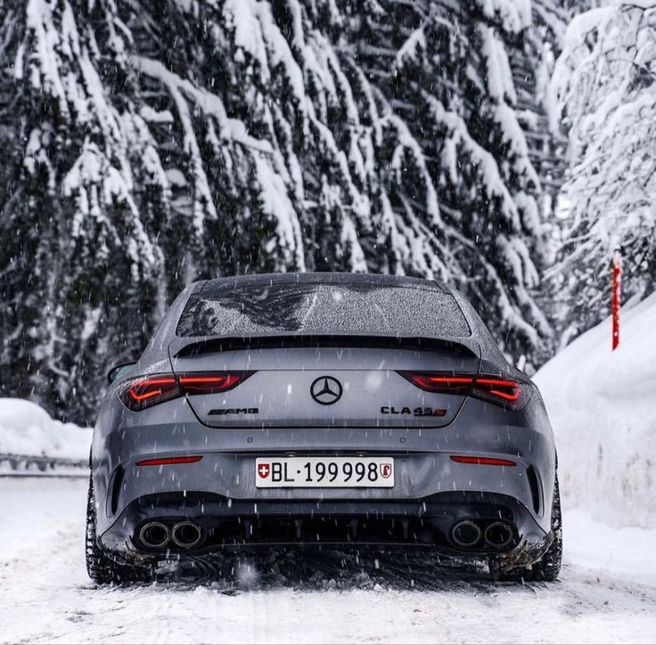 the rear end of a car driving down a snow covered road