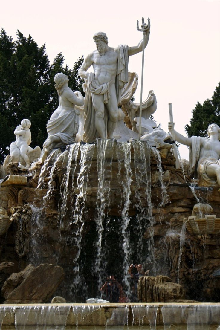 there is a fountain with statues on it and water coming out of the top one