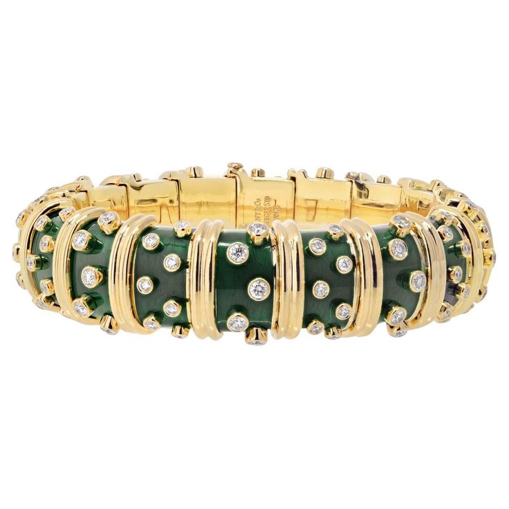 Tiffany & Co. Schlumberger 18K Yellow Gold Deep Bright Green Enamel And Diamond Bracelet. An exquisite creation, a dark green paillonne enamel hinged bangle by Jean Schlumberger that encapsulates the brilliance of design and craftsmanship. This bangle is adorned with collet-set diamonds, each sparkling with its unique radiance, while sculpted 18k gold vertical bands add a touch of luxury. A marriage of artistry and elegance, this piece is signed Schlumberger for the renowned Jean Schlumberger an Jean Schlumberger, Modern Bangle, Yellow Jewelry, French Jewelry, Enamel Bangle, Diamond Bangles Bracelet, Tiffany And Co, Diamond Bangle, Green Enamel