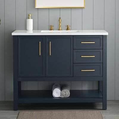 a bathroom vanity with two sinks and a gold framed painting on the wall above it