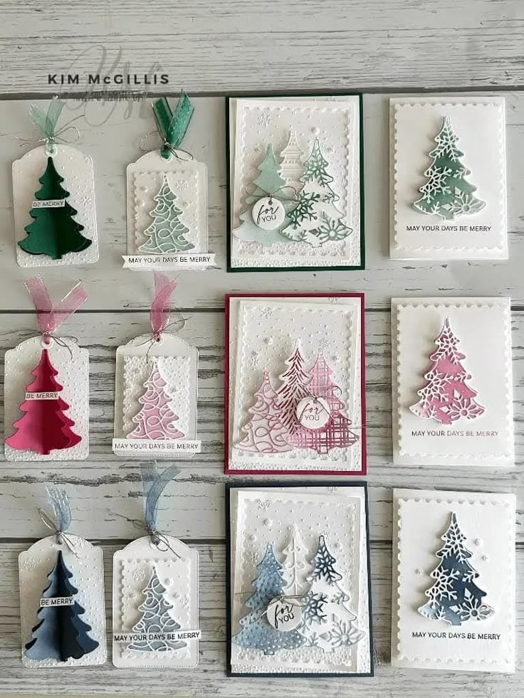 some cards with christmas trees on them and tags hanging from the top, all decorated in different colors