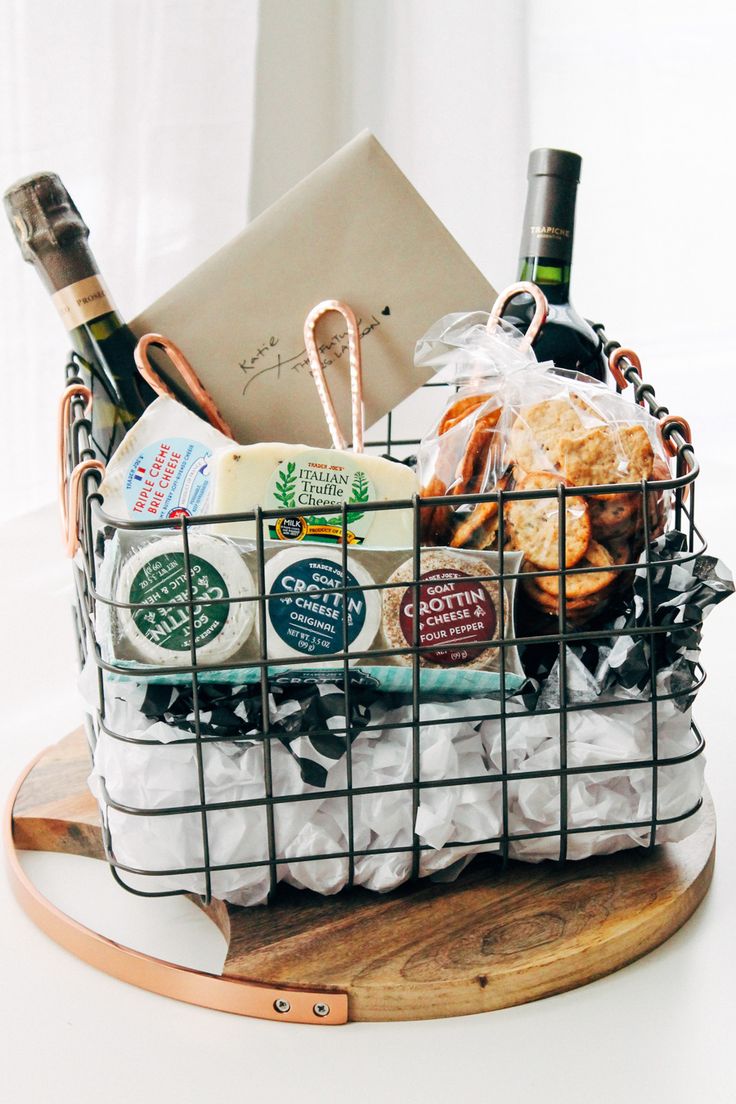 a basket filled with wine, cheese and bread