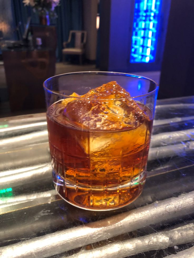 a glass filled with ice sitting on top of a table