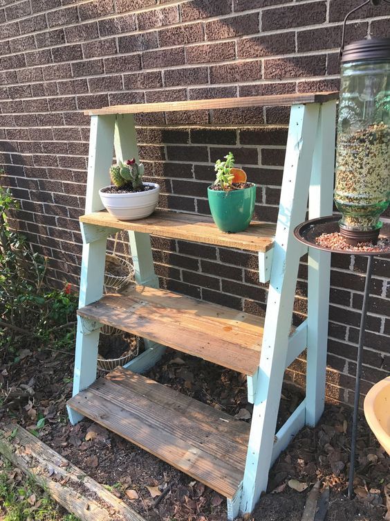 an old ladder is used as a shelf for plants