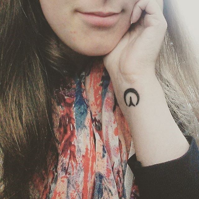 a woman with a peace sign tattoo on her wrist