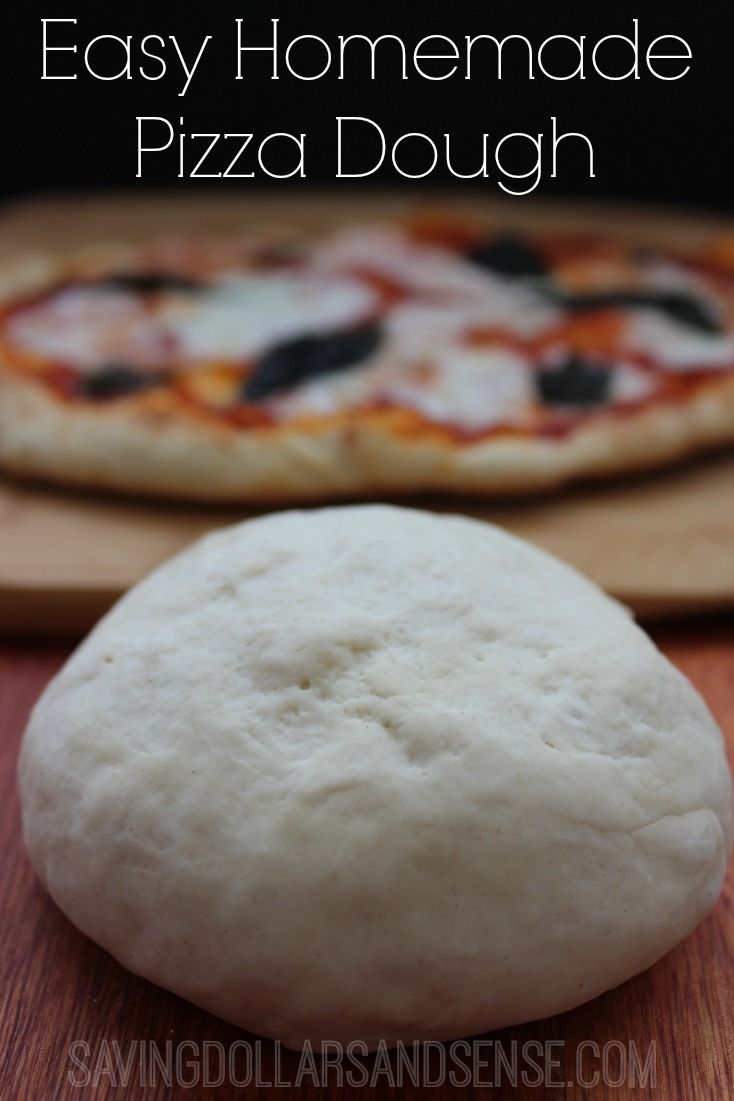 homemade pizza dough sitting on top of a wooden cutting board