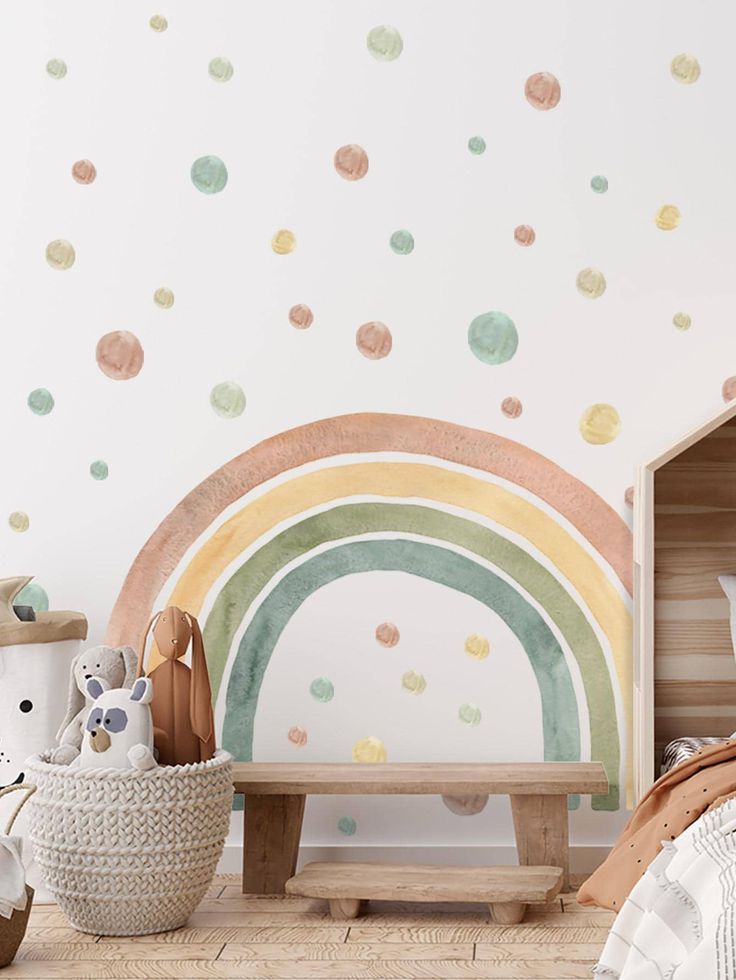 a child's bedroom with polka dot wall decals and a rainbow painted on the wall