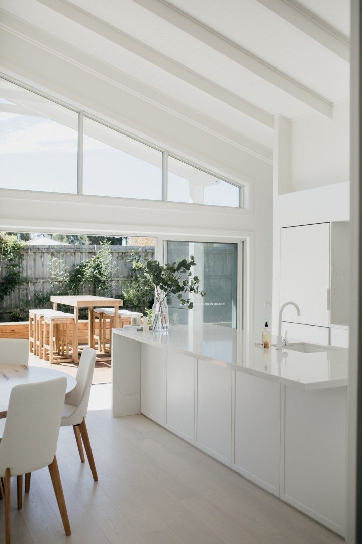 an open kitchen and dining room with white furniture