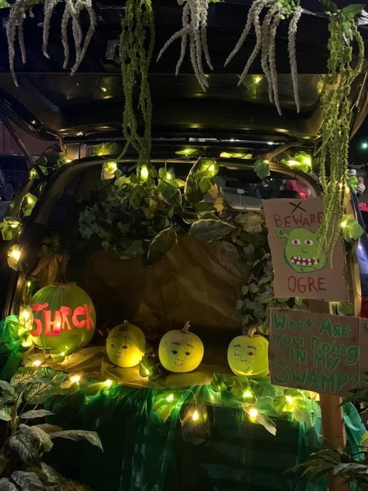 the trunk of a car decorated with lights and pumpkins for halloween time at night