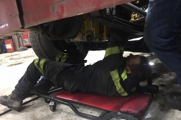 a man laying on the ground under a car