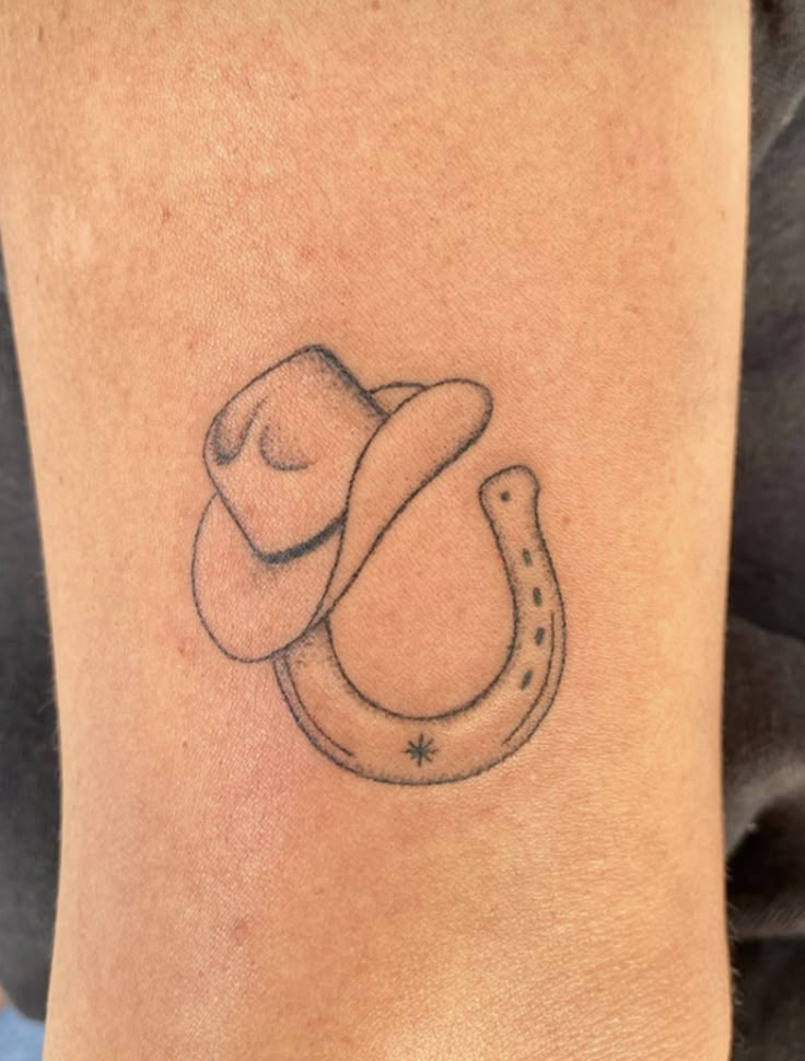 a tattoo with a horseshoe and a hat on it