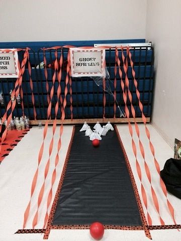 some red balls and orange streamers on a black mat in the middle of a room