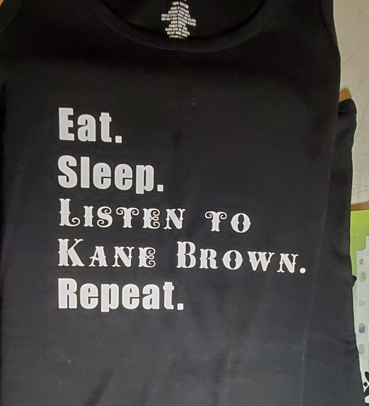 a black shirt with white writing on it that says eat sleep listen to kanee brown repeat