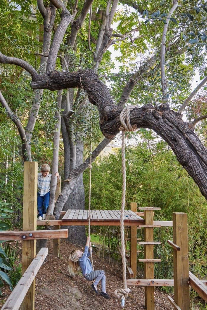 two people on swings in the woods