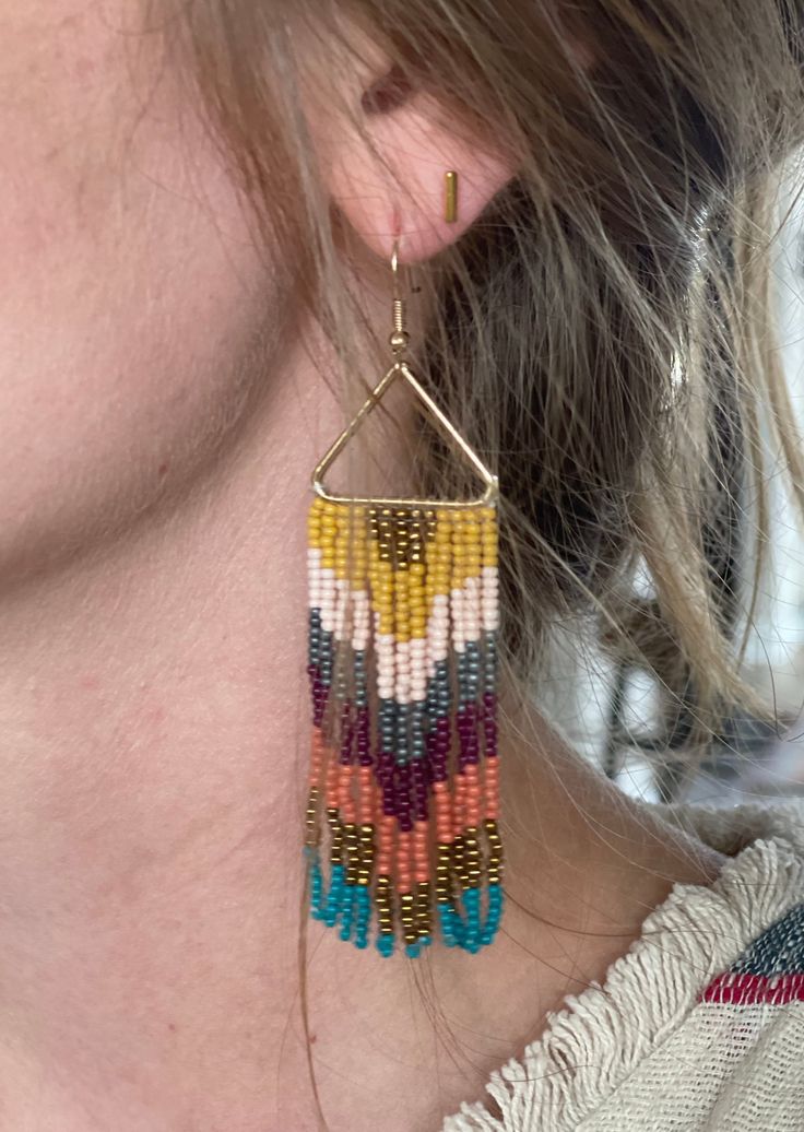 These Triangle Fringe Beaded Earrings are the perfect way to accessorize any look. Crafted from quality beads, they offer a lightweight and comfortable fit. With a unique triangle shape and detailed dangling fringe, you can make a stylish statement. Length: 3.75" Color: gold, mustard yellow, pink, silver, burgundy, terracotta and teal Fringe Earring Pattern, Fringe Beaded Earrings, Fringe Earring, Earring Patterns, Triangle Shape, Fringe Earrings, Jewelry Diy, Color Ideas, Mustard Yellow