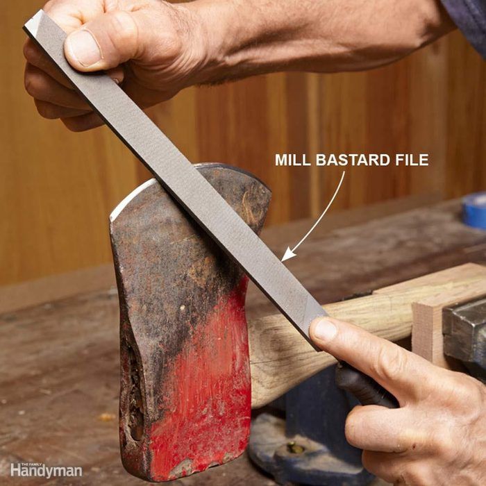 a man is holding a large knife in his right hand while working on a piece of wood