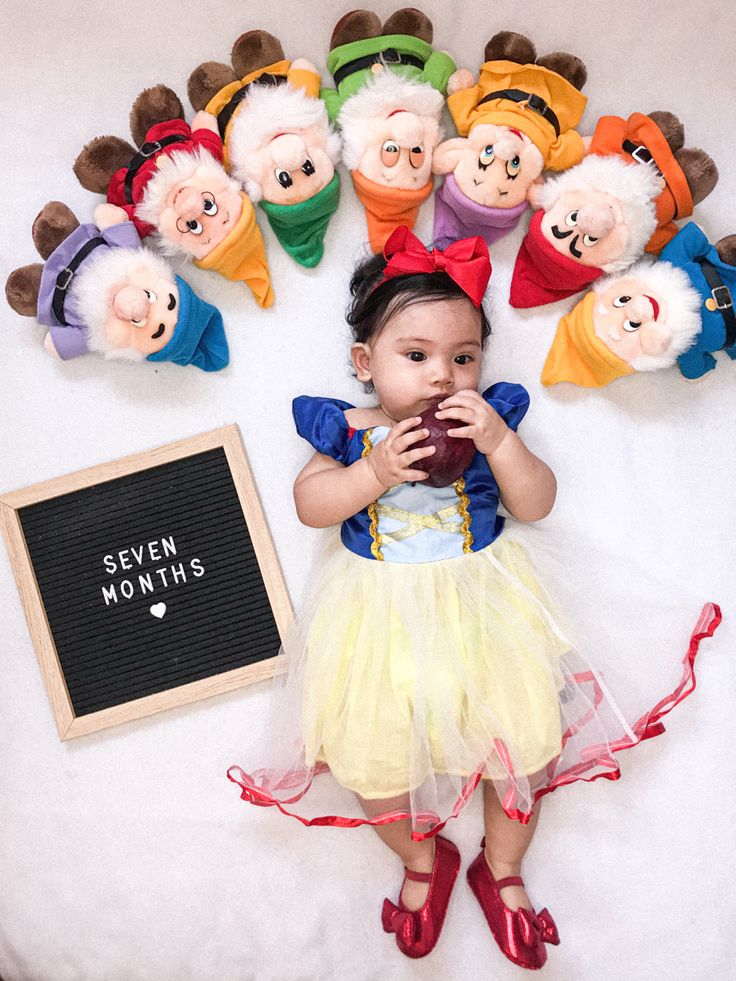 there is a baby girl that is surrounded by stuffed animals