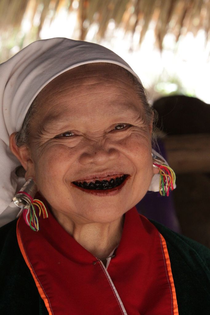 an older woman wearing a turban smiles at the camera