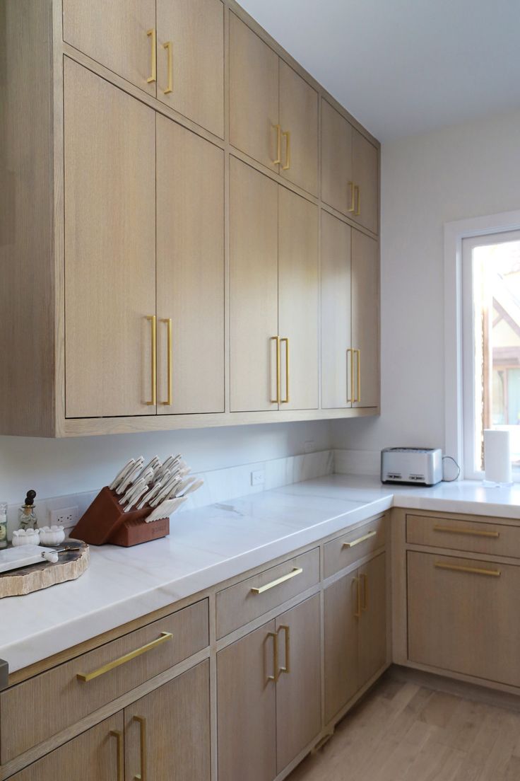 a kitchen with wooden cabinets and white counter tops