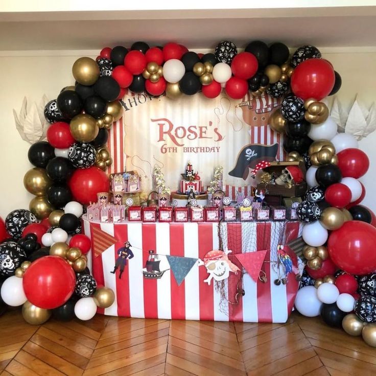 a table topped with lots of balloons next to a red and white striped table cloth