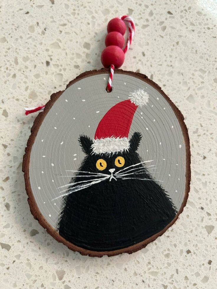 a christmas ornament with a black cat wearing a santa hat