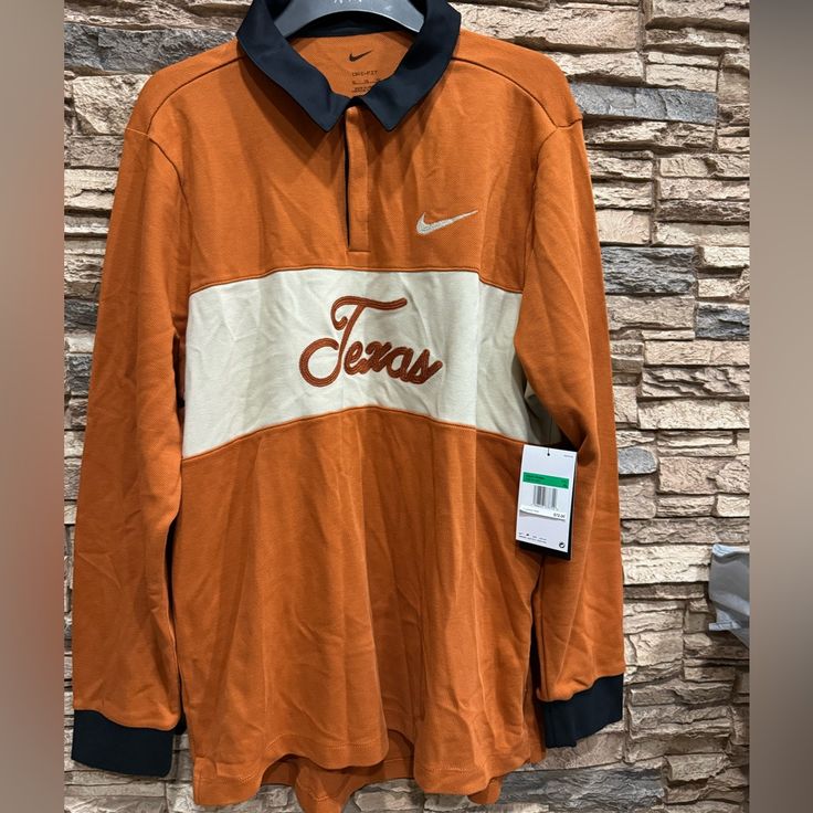 an orange and white shirt with the word jesus on it is hanging in front of a brick wall