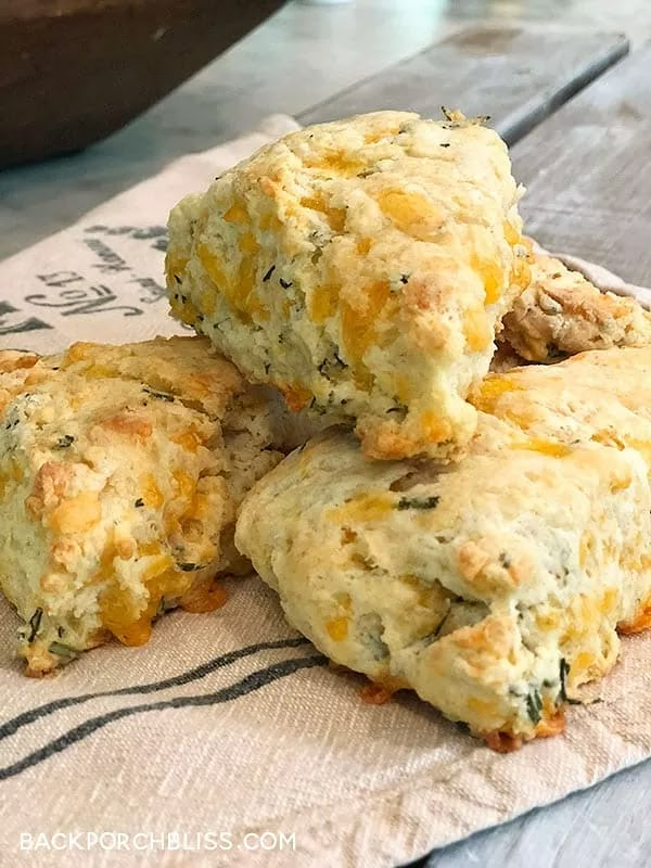 four biscuits stacked on top of each other on a napkin next to a potted plant