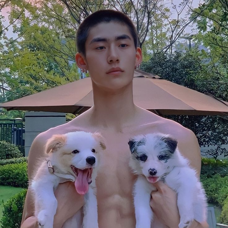 a man holding two puppies in his arms