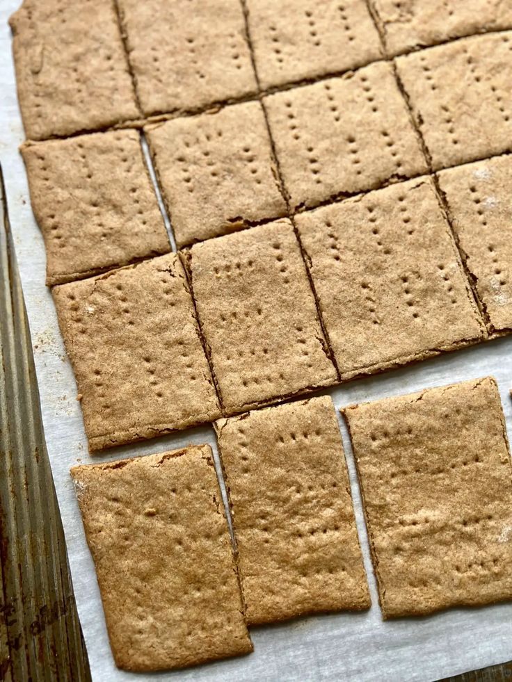 crackers are laid out on a piece of parchment paper to be cut into squares