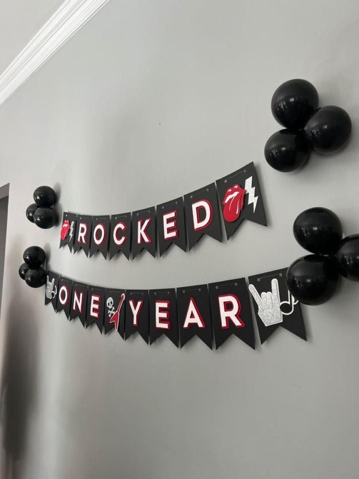 a black and red party banner that says rocked one year