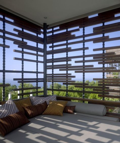 a bed sitting on top of a wooden floor next to a window covered in blinds