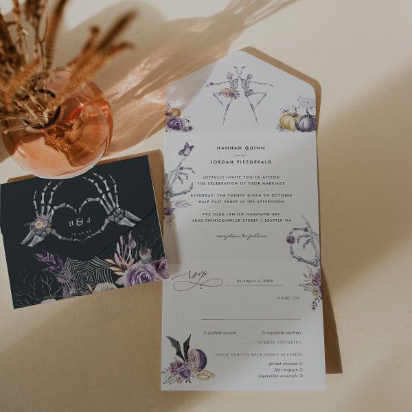 the wedding stationery is next to an orange vase with dried flowers and feathers on it