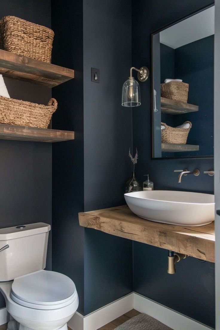 a white toilet sitting next to a sink in a bathroom under a wooden shelf with baskets on it