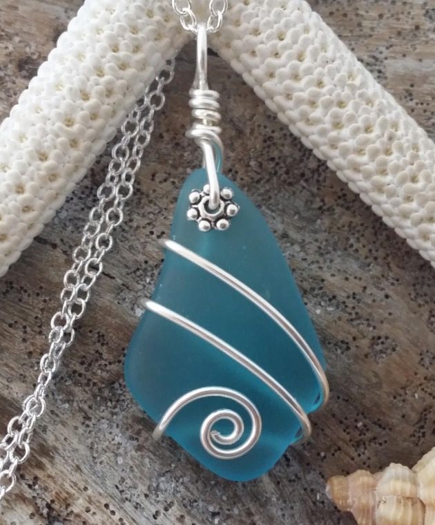 a blue sea glass pendant on a silver chain