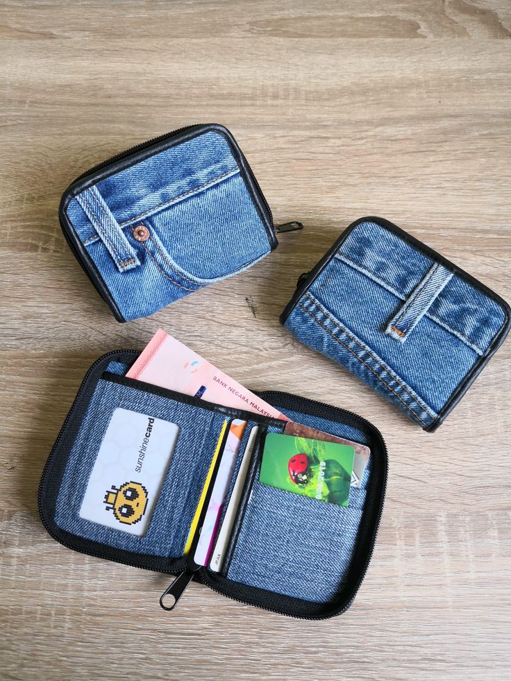 two wallets with credit cards in them on a wooden table next to an empty wallet